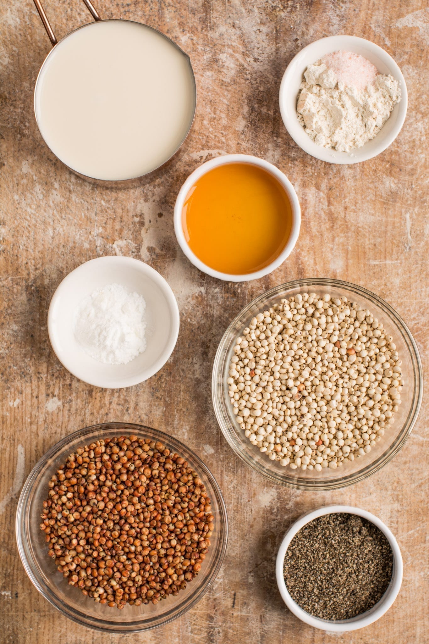 Ingredients for vegan savoury sorghum muffins on wooden surface.