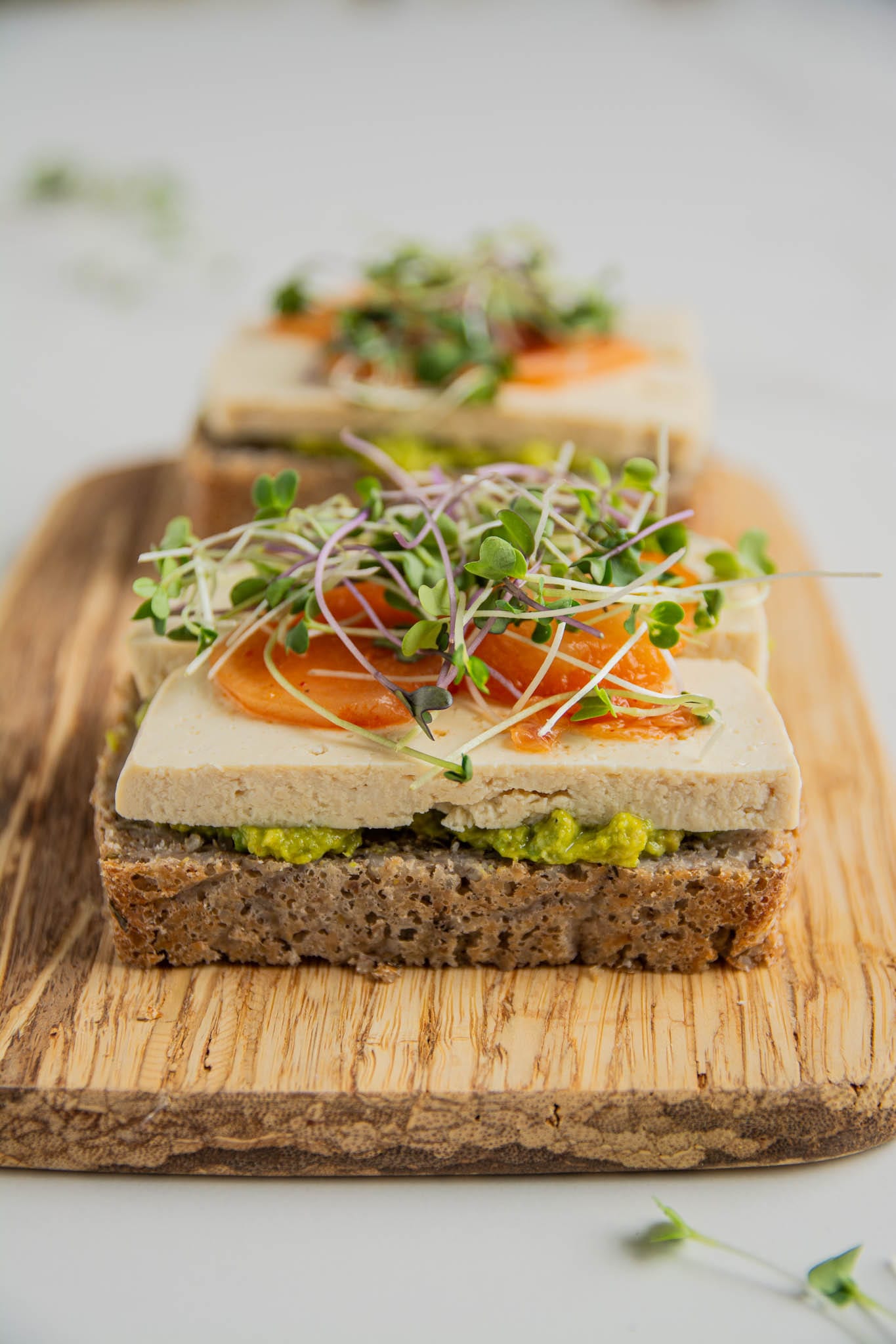 Gluten-free sourdough bread sandwich with avocado spread, tofu and kimchi.