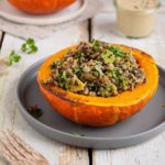 Learn how to make delicious and hearty festive vegan stuffed pumpkin with lentils, quinoa, and mushrooms. Moreover, my creamy and herby cashew-miso dressing will make this dish extra luscious.